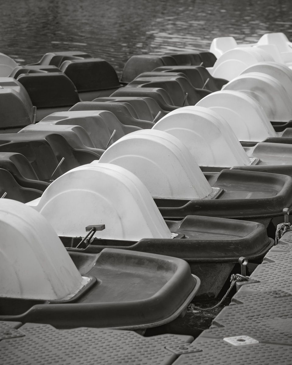 A row of empty seats sitting next to a body of water